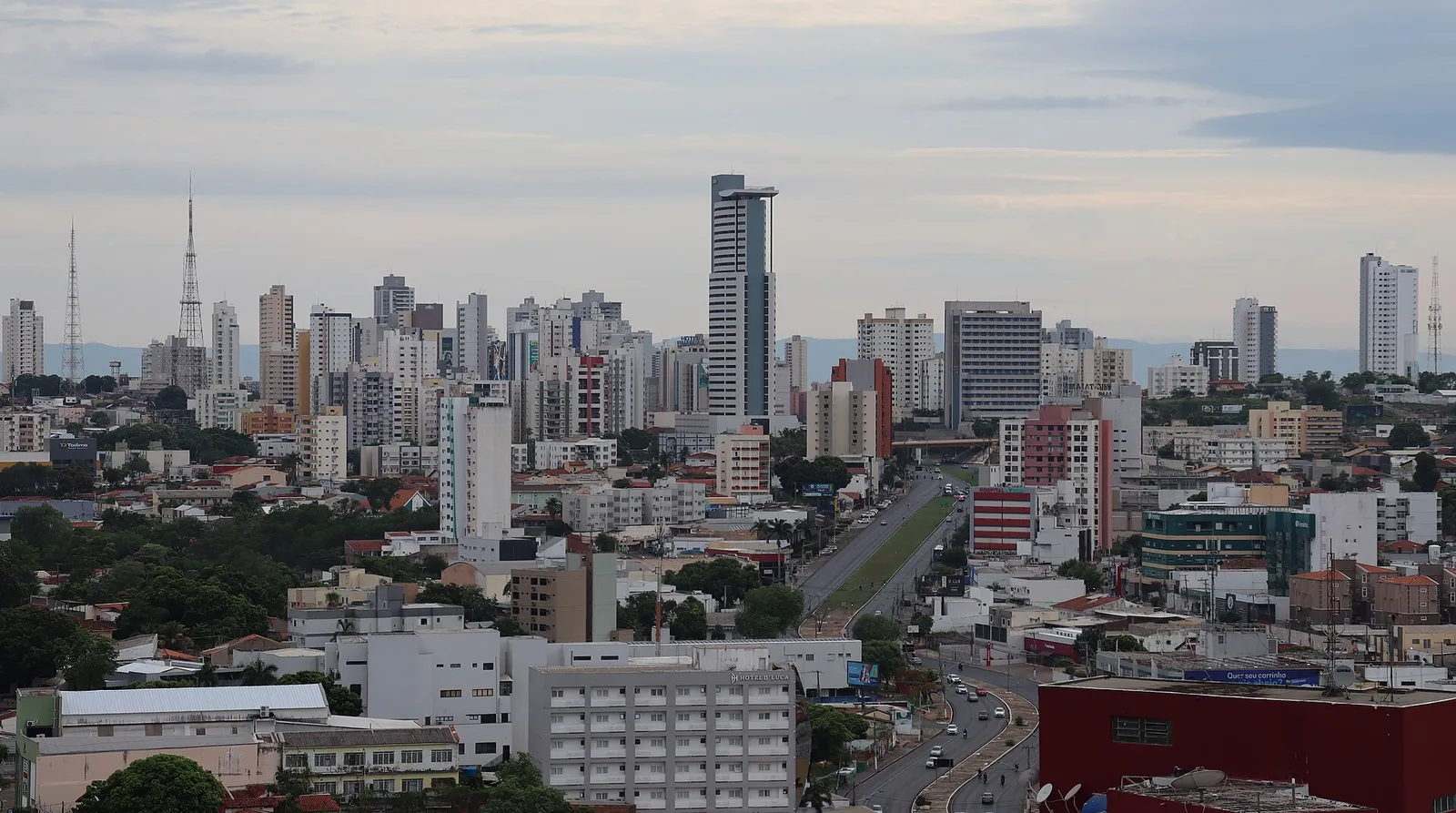 Vista do centro de Cuiabá (MT), com prédios altos e uma avenida ao centro sob céu nublado