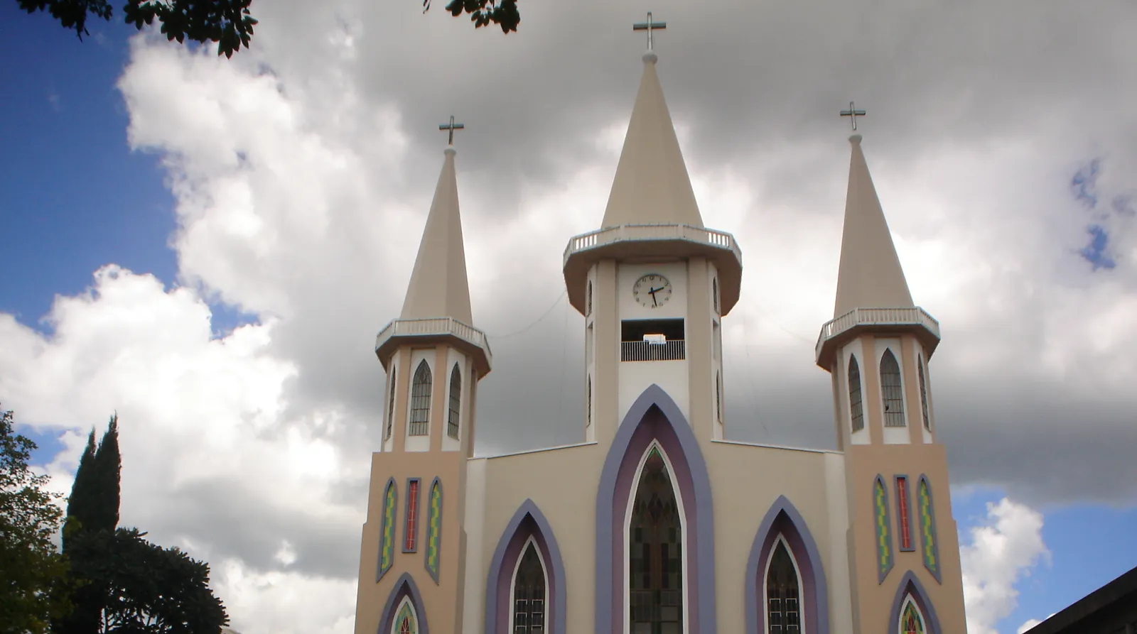 Igreja Central de Xanxerê, em Santa Catarina, com três torres e janelas em arco sob céu nublado